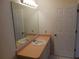 Bathroom featuring a mirror, sink, and closed door at 1219 Santos Pl, Lady Lake, FL 32159