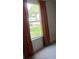 Bedroom featuring a window with rust-colored curtains and a lush green view at 1219 Santos Pl, Lady Lake, FL 32159