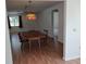 Open dining area featuring laminate wood floors, a vintage light fixture, and dark wood furniture at 1219 Santos Pl, Lady Lake, FL 32159