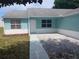 Close-up of the home's entrance featuring a white door, clean windows, and low-maintenance landscaping at 1219 Santos Pl, Lady Lake, FL 32159