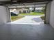 Open garage showing the paved driveway, the house across the street, and green lawn at 1219 Santos Pl, Lady Lake, FL 32159