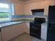 Charming kitchen features light wood cabinets, black appliances, and a sink with a view to the outside at 1219 Santos Pl, Lady Lake, FL 32159