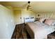 Bedroom features wood floors, floral bedding, woven pendant light, and white storage at 18700 Ravenswood Rd, Altoona, FL 32702