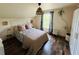 Charming bedroom with a floral bedspread, natural light, wood floors, and neutral color tones at 18700 Ravenswood Rd, Altoona, FL 32702