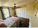 Bedroom with wood floors, woven pendant light, floral bedding, and large wardrobe at 18700 Ravenswood Rd, Altoona, FL 32702