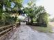 View of the driveway leading to the beautiful two-story home surrounded by lush trees and greenery at 18700 Ravenswood Rd, Altoona, FL 32702