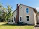 Exterior view of the two-story home featuring a brick chimney, white framed windows, and a screened porch at 18700 Ravenswood Rd, Altoona, FL 32702