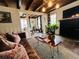 Open-concept living room with exposed beams, brick fireplace, and a comfortable sitting area at 18700 Ravenswood Rd, Altoona, FL 32702