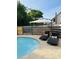 View of the pool with lounge chairs and a cantilever umbrella by the wood fence at 18700 Ravenswood Rd, Altoona, FL 32702