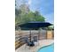 Poolside seating area with two chairs and an umbrella near the pool and fence at 18700 Ravenswood Rd, Altoona, FL 32702