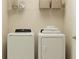 Bright laundry room features a washer and dryer, complemented by storage shelves above for organized convenience at 4734 Bold Peacock Bnd, Bartow, FL 33830