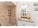 Beautiful bathroom featuring tiled shower with shelves and granite countertop vanity at 933 W Queen St, Lakeland, FL 33803