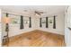 Large bedroom with hardwood floors, a ceiling fan, and three windows at 933 W Queen St, Lakeland, FL 33803