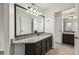 Bathroom with dark cabinets, granite counters, a large vanity mirror and tile flooring at 490 N Pin Oak Pl # 112, Longwood, FL 32779