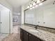 Bathroom featuring dark wood cabinets, granite counters, and a large vanity mirror at 490 N Pin Oak Pl # 112, Longwood, FL 32779