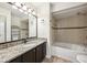 Bathroom featuring neutral tile, dark cabinets, granite counters, and a shower-tub combination at 490 N Pin Oak Pl # 112, Longwood, FL 32779