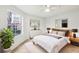 Cozy bedroom features natural light from a window, a comfy bed and stylish decor and a ceiling fan at 490 N Pin Oak Pl # 112, Longwood, FL 32779
