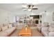 Bright living room showcases an open floor plan with a kitchen island and dining area, plus a ceiling fan and neutral furnishings at 490 N Pin Oak Pl # 112, Longwood, FL 32779