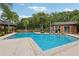 Community pool with a bathhouse, sun loungers, and lush tropical landscaping at 490 N Pin Oak Pl # 112, Longwood, FL 32779
