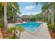 Community pool with a bathhouse, sun loungers, and lush tropical landscaping at 490 N Pin Oak Pl # 112, Longwood, FL 32779