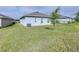 Expansive backyard showcasing lush lawn and the home's light blue exterior at 670 Campo Ln, Davenport, FL 33837