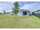 The well-maintained backyard features green grass, a partially covered patio, and perimeter fencing at 670 Campo Ln, Davenport, FL 33837