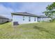 The backyard features lush grass, light blue exterior, and a partially covered patio at 670 Campo Ln, Davenport, FL 33837