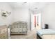 Bright bedroom features a crib, changing table, bed and access to the bathroom at 670 Campo Ln, Davenport, FL 33837