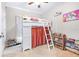 Bright bedroom featuring a loft bed with ladder, shelving and storage, and light neutral tones throughout at 670 Campo Ln, Davenport, FL 33837