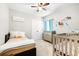 Bright bedroom features a bed, crib, changing table, and ceiling fan at 670 Campo Ln, Davenport, FL 33837