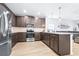 Modern kitchen featuring stainless steel appliances, dark wood cabinets, and a breakfast bar with pendant lighting at 670 Campo Ln, Davenport, FL 33837