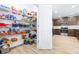 Well-organized pantry with shelving overflowing with groceries, adjacent to a modern kitchen area at 670 Campo Ln, Davenport, FL 33837