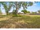 A lush backyard with mature trees that provides ample shade and an expansive grassy area at 114 Valencia Loop, Altamonte Springs, FL 32714