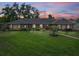 Charming single-story home with a well-manicured lawn and lush landscaping at sunset at 114 Valencia Loop, Altamonte Springs, FL 32714