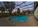 Enclosed pool area with a beautiful kidney-shaped pool, lush greenery, and a serene backyard setting at 114 Valencia Loop, Altamonte Springs, FL 32714