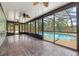 Covered patio area with ceiling fans, brick flooring and enclosed view of pool area at 114 Valencia Loop, Altamonte Springs, FL 32714