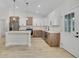 Modern kitchen featuring stainless steel appliances, a center island, white and wood-look cabinets and adjacent dining area at 16538 Sw 31St Terrace, Ocala, FL 34473