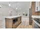 Bright open kitchen with stainless appliances and a central island featuring a microwave at 16538 Sw 31St Terrace, Ocala, FL 34473