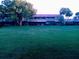 Serene backyard featuring a lush lawn, beautiful shade trees, and tropical landscaping at 2500 21St Nw St # 71, Winter Haven, FL 33881