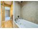 Bathroom showcasing white whirlpool tub, tiled walls, and chrome plumbing fixtures at 2500 21St Nw St # 71, Winter Haven, FL 33881