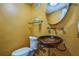 Bathroom featuring toilet, glass bowl sink, chrome plumbing fixtures and yellow textured walls at 2500 21St Nw St # 71, Winter Haven, FL 33881