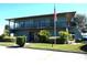 A two story clubhouse building with an American flag and well manicured landscaping at 2500 21St Nw St # 71, Winter Haven, FL 33881