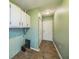 Hallway features tile flooring, overhead storage, a white entry door and light green painted walls at 2500 21St Nw St # 71, Winter Haven, FL 33881