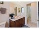 Neutral bathroom vanity with sink, mirror, and an open doorway to a hallway upstairs at 10292 Kristen Park Dr, Orlando, FL 32832