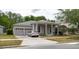 Charming single-story home with columns, a well-manicured lawn, and a three-car garage at 10292 Kristen Park Dr, Orlando, FL 32832