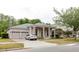 Charming single-story home with columns, a well-manicured lawn, and a three-car garage at 10292 Kristen Park Dr, Orlando, FL 32832