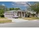 Inviting single-story home featuring stately columns, lush landscaping, and an attached two-car garage at 10292 Kristen Park Dr, Orlando, FL 32832