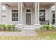 Inviting front porch featuring classic columns, double windows, and a stylish brown front door at 10292 Kristen Park Dr, Orlando, FL 32832