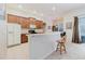 An open kitchen boasts a breakfast bar, wood cabinets, stainless appliances, and tile floors for easy maintenance at 10292 Kristen Park Dr, Orlando, FL 32832