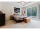 Bright and airy main bedroom featuring tray ceiling and sliding glass doors to lanai at 10292 Kristen Park Dr, Orlando, FL 32832